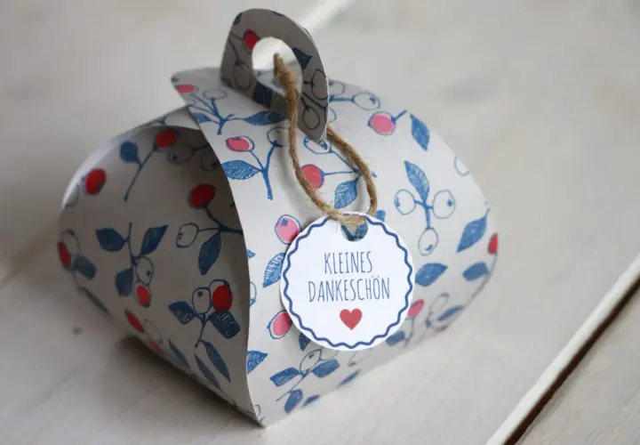 Eine liebevoll gestaltete DIY Geschenkbox mit Beerenmuster und dem Anhänger "Kleines Dankeschön".