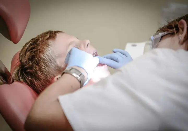 Chłopiec u dentysty, który sprawdza jego podniebienie zdrowe.