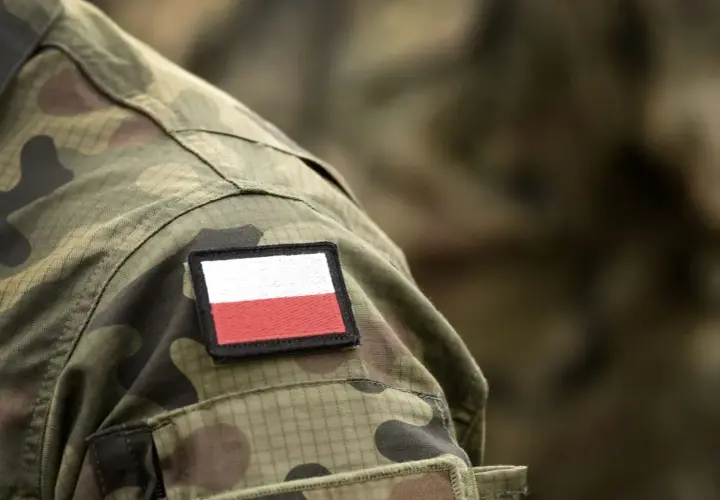 Na mundurze widoczna naszywka z flagą Polski. To symbol dumy i tradycji, nawiązujący do historii, w tym do stopni wojskowych II RP.
