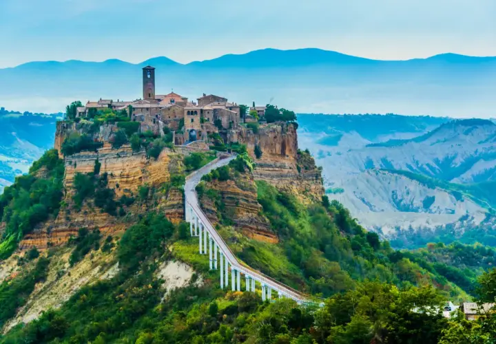 Civita di Bagnoregio, un borgo antico arroccato su una rupe, collegato da un ponte pedonale.