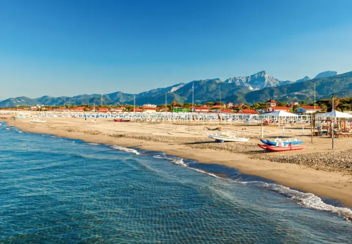 Plage de sable fin, mer bleue et montagnes en arrière-plan. Idéal pour savoir où aller en Toscane bord de mer.