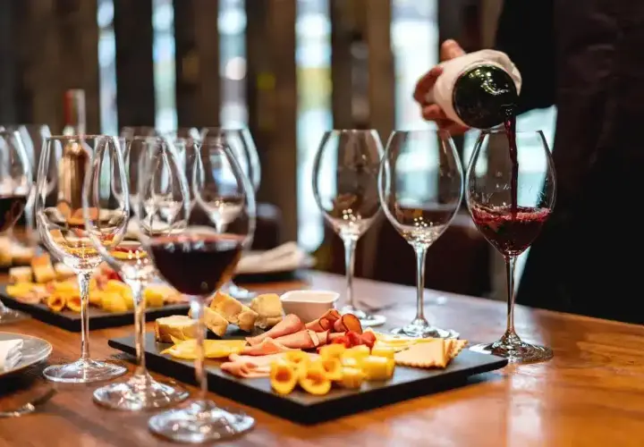 Une dégustation de vin à Paris, avec des verres remplis de vin rouge et des plateaux de fromages et charcuteries.