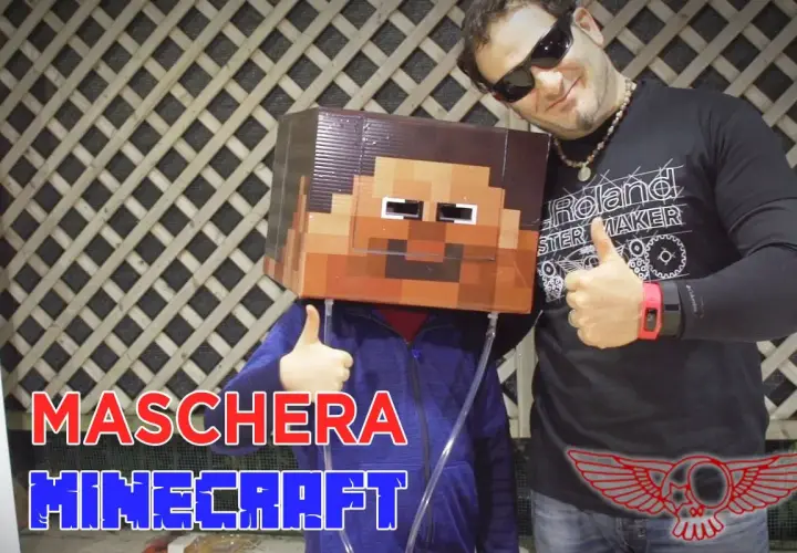 Un bambino indossa una maschera fai da te di Minecraft. Un uomo sorride e fa il pollice in su.