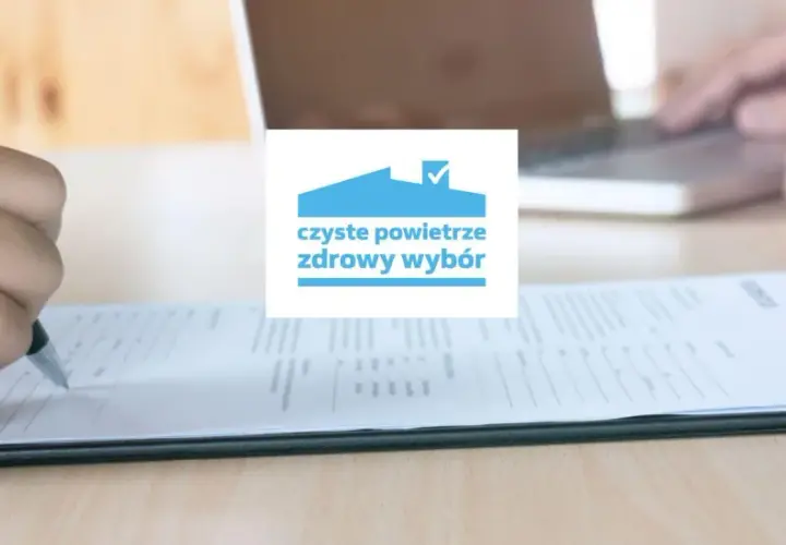 Dłoń pisząca na formularzu, logo "czyste powietrze zdrowy wybór".