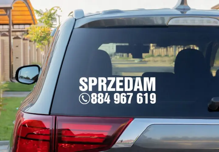 Nalepka na szybę samochodu z napisem "SPRZEDAM" i numerem telefonu.