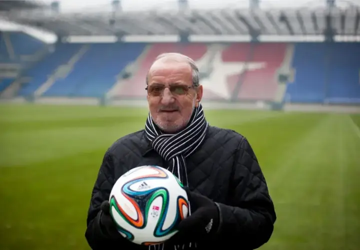Wojciech Kwiecień, z piłką w rękach, na tle stadionu. Jego majątek to lata pracy i pasji do futbolu.