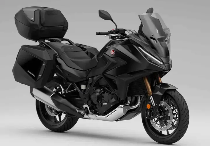 Moto automática Honda negra, lista para viajar con maletas laterales y top case.