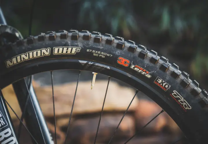 Close-up of a Maxxis Minion DHF tire, 27.5x2.50WT, 50 PSI, EXO Protection, TR. Ready for any trail, unlike the DHR.