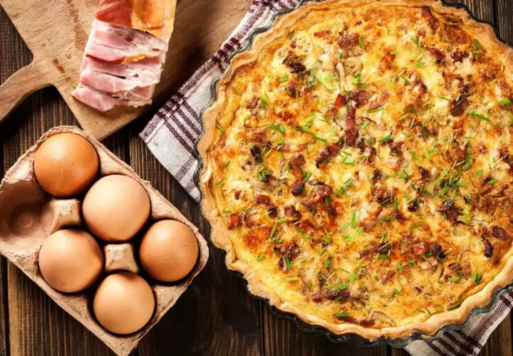 Comment faire une quiche : ingrédients pour une quiche savoureuse : œufs, lardons, et une belle quiche dorée prête à être dégustée.