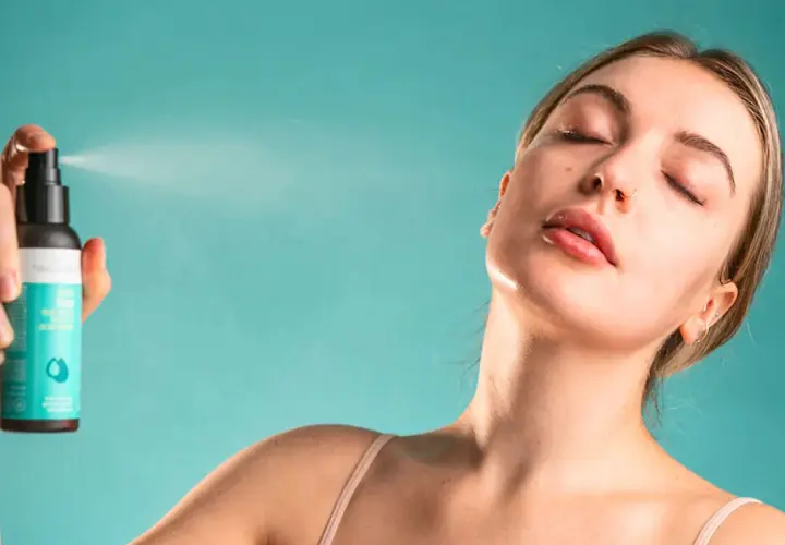 Une femme reçoit une brume rafraîchissante sur le visage. Une brume sert à hydrater et revitaliser la peau.