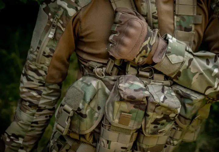 Żołnierz w mundurze w kamuflażu multicam, z rękawicami i kamizelką taktyczną. Materiał to wytrzymała cordura 500 czy 1000?