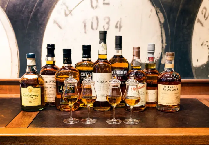 Rząd butelek whisky, w tym Dalwhinnie 15, Balvenie 12, Jura, Oban, Glenmorangie, Monkey Shoulder. Czy warto kupować whisky bez określenia wieku (NAS)?