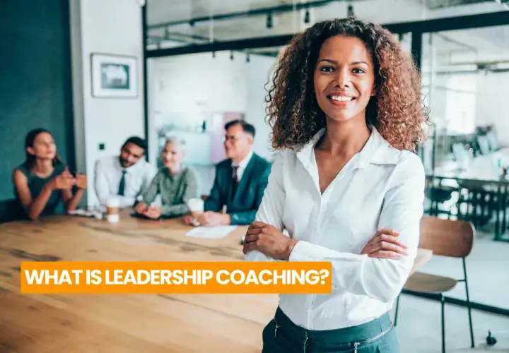 A confident woman leads a team meeting, embodying the essence of leadership coaching definition.