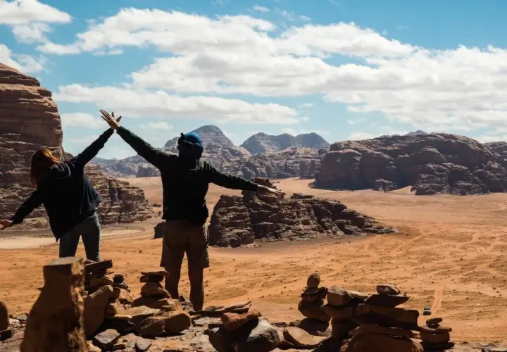 Dwie osoby cieszą się widokiem pustyni Wadi Rum. Odpowiedź na pytanie: czy w Jordanii jest bezpiecznie? Tak, podróżni czują się tu swobodnie.