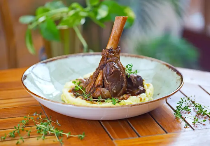 Une souris d'agneau braisée, servie sur une purée onctueuse et garnie de thym frais. Un plat savoureux et réconfortant.