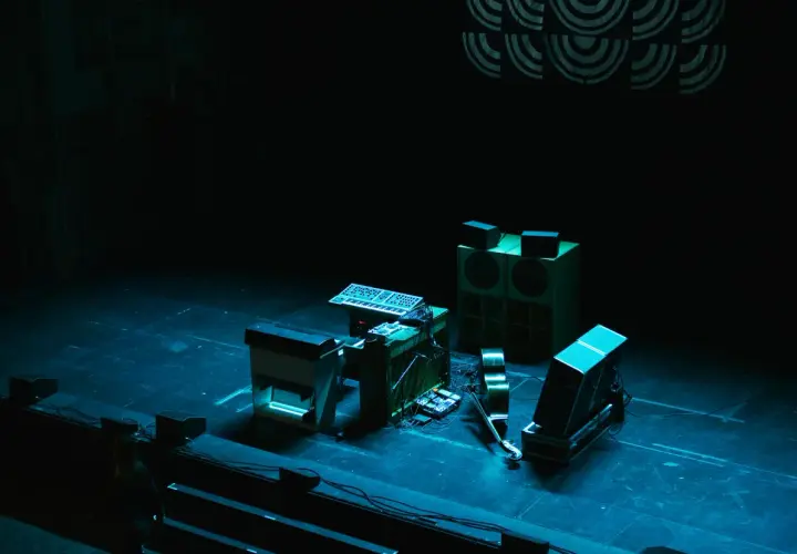 Scen för jazzfestival med synthesizers, högtalare och en fiol.