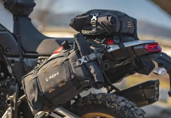 Borsa roll bag nera fissata sul retro di una moto da enduro, pronta per un'avventura.