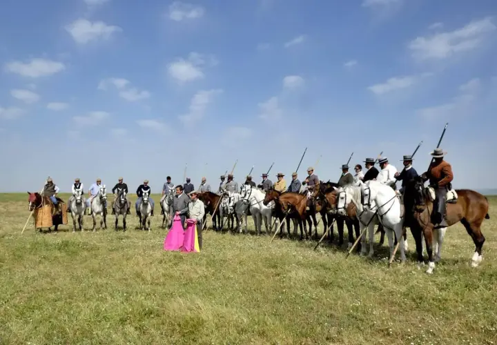Hombres a caballo, algunos con trajes de luces, listos para la lidia. Eduardo Miura, un nombre ligado a la tauromaquia, podría estar entre ellos.