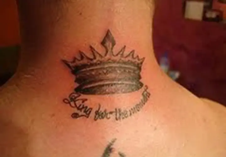 Męski tatuaż na szyi: korona z napisem "King for the moment".