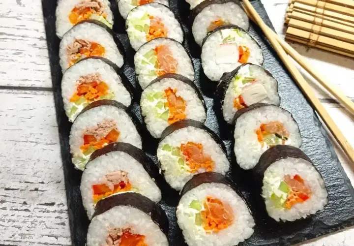 Gotowe sushi z łososiem, tuńczykiem i warzywami. Prosty sposób, jak zawinąć sushi, by wyglądało apetycznie.