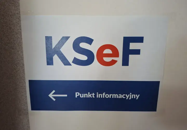 Tabliczka z napisem KSeF i strzałką w lewo do Punktu informacyjnego. Kto wymyślił KSeF? Zapytaj tutaj.
