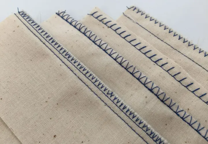 Close-up of beige fabric with neat, blue serger stitches. This is what a serger does: finishes edges beautifully.