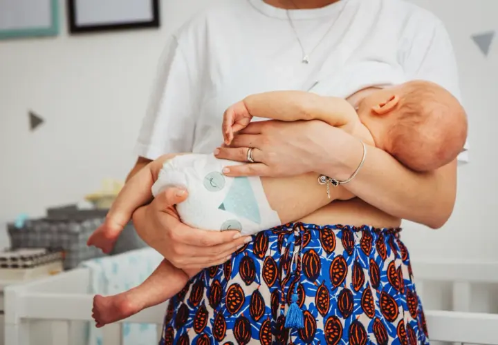 Mama tuli dziecko, które mogło się przegrzać. Widać pieluszkę i jej ramiona.