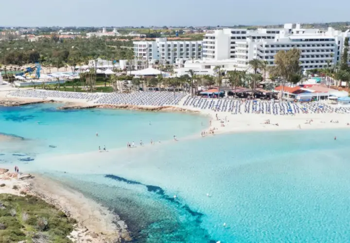 Piękna plaża z turkusową wodą i białymi hotelami. Czy Cypr to państwo, które oferuje takie widoki? Tak, to raj dla turystów!
