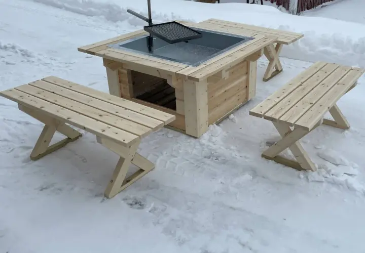 En ny grillplats i trä med bänkar, perfekt för grillplats inspiration i vinterlandskapet.