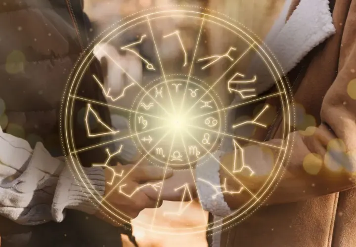 Zodiakalny krąg z symbolami gwiazd, w tym panna, otacza dłonie pary.