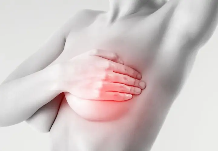 Mano che copre il seno con un'area rossa che indica bruciore e ansia.