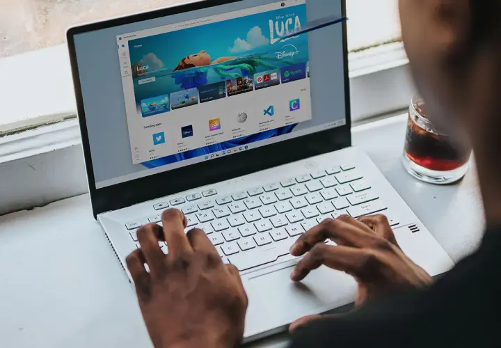 Osoba korzysta z laptopa z systemem Windows 11, przeglądając sklep z aplikacjami. Czy Windows 11 jest darmowy? Sprawdźmy!
