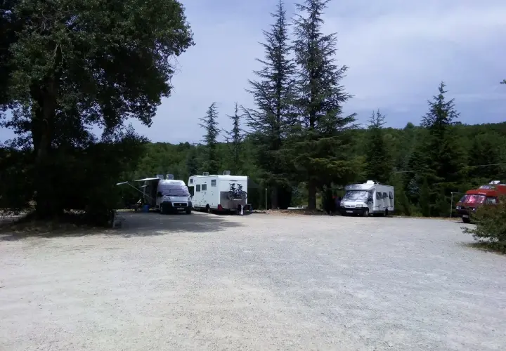 Aire de camping-car dans les Gorges du Verdon. Plusieurs camping-cars stationnés sous les arbres, prêts pour l'aventure.