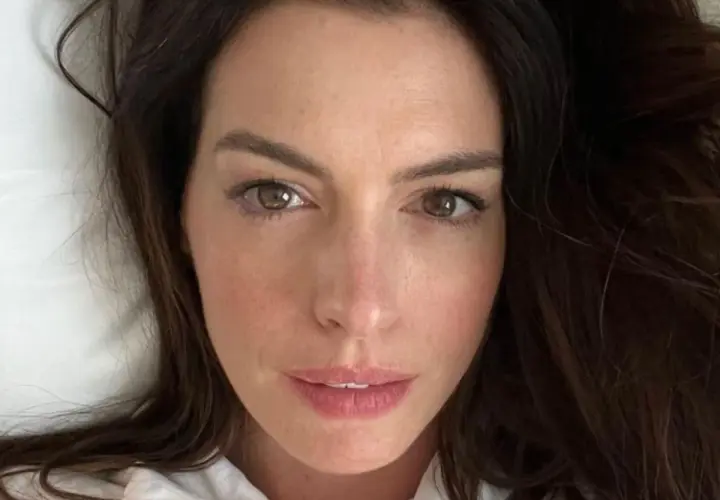 Zbliżenie na twarz Anne Hathaway. Aktorka ma brązowe oczy i ciemne włosy. Wiele osób zastanawia się, ile lat ma Anne Hathaway, ale na tym zdjęciu wygląda młodo i promiennie.
