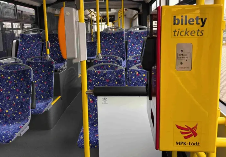Wnętrze autobusu MPK-Łódź. Żółty automat biletowy z napisem "bilety tickets" obok siedzeń. Sprawdź bus łódź - uniejów cennik.