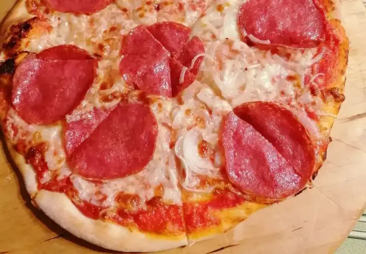 Pizza z serem i plasterkami salami, które dodają jej wyrazistego smaku. Różne rodzaje salami na pizzy to prawdziwa uczta dla podniebienia.