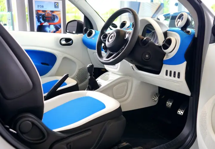 Wnętrze samochodu Smart. Widoczne pedały: po lewej hamulec, po prawej gaz.