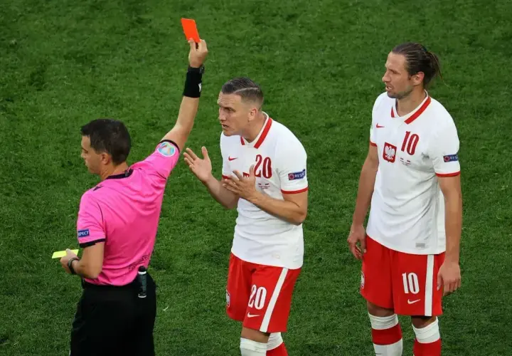 Sędzia pokazuje czerwoną kartkę, co oznacza koniec gry dla zawodnika.