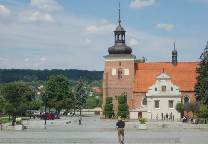 Włocławek atrakcje na weekend: plac z zabytkową katedrą, zielony park i ludzie spacerujący w słoneczny dzień.