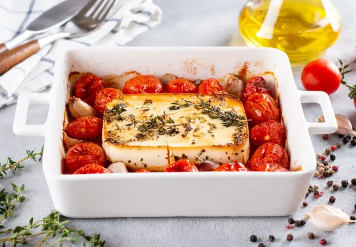Zapiekany ser feta z pomidorkami koktajlowymi i czosnkiem. Idealne szybkie danie na gorąco dla gości, pachnące ziołami.
