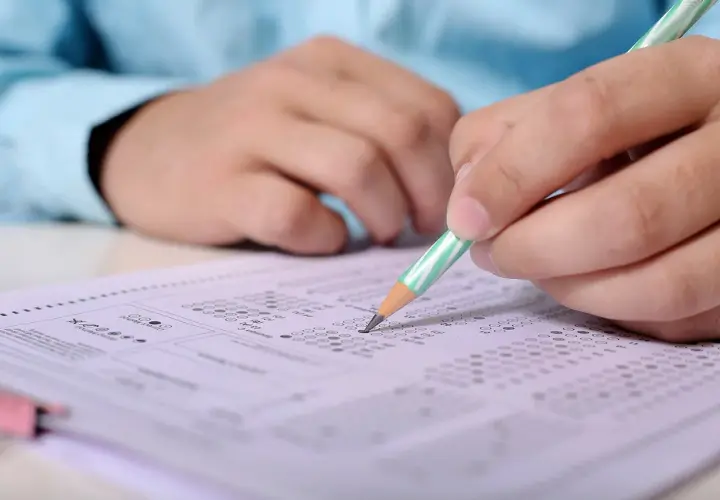 Ręka z ołówkiem zaznacza odpowiedzi na arkuszu egzaminacyjnym. Przygotowanie do egzaminu SEP, pytania i odpowiedzi.