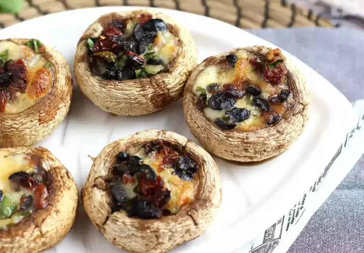 Champignons farcis aux olives et tomates séchées, gratinés au fromage. Un délice à déguster !