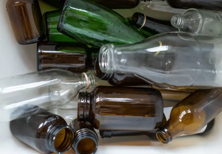 Stos szkła do recyklingu: brązowe i zielone butelki, ciekawe ciekawostki o recyklingu.