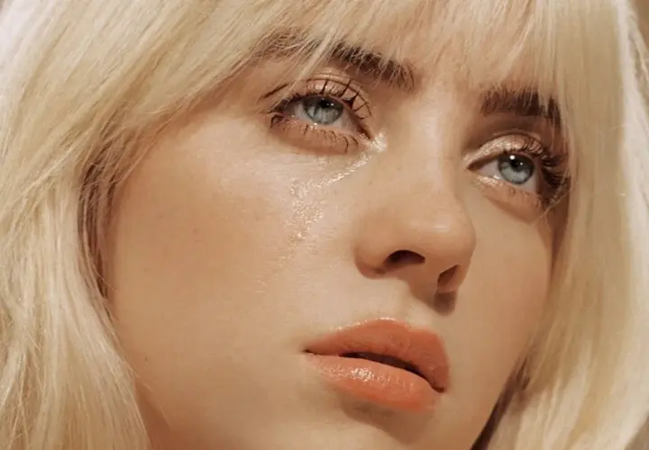 Billie Eilish, z niebieskimi oczami i blond włosami, w kadrze z jej piosenki "Therefore I Am".