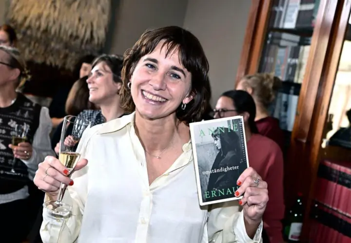 Lisa Lindberg håller upp boken "Annie Ernaux: Omständigheter" vid ett Norstedts-event.
