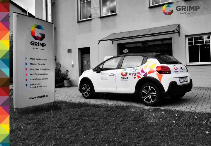 Samochód firmowy GRIMP z kolorowym brandingiem, gotowy do wycofania z firmy. Obok tablica informacyjna z usługami.