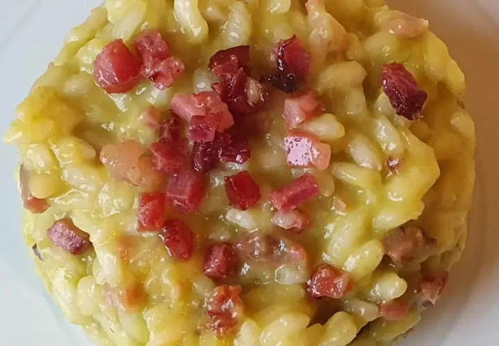 Un cremoso risotto con asparagi e pancetta croccante, un piatto ricco di sapore e profumo.