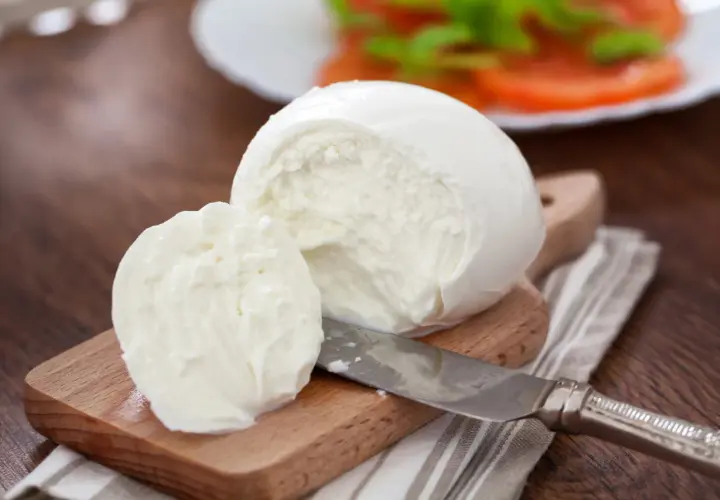Świeża mozzarella na desce, gotowa do sałatki. Zastanawiasz się, ile tłuszczu ma mozzarella?