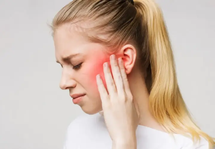 Donna con dolore al viso, area rossa indica possibile nevralgia denti o infiammazione.