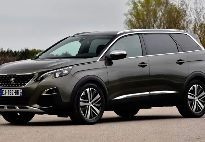 Szary Peugeot 5008 na drodze, widoczne felgi i opony. Rozmiar opon jest kluczowy dla komfortu jazdy tym SUV-em.